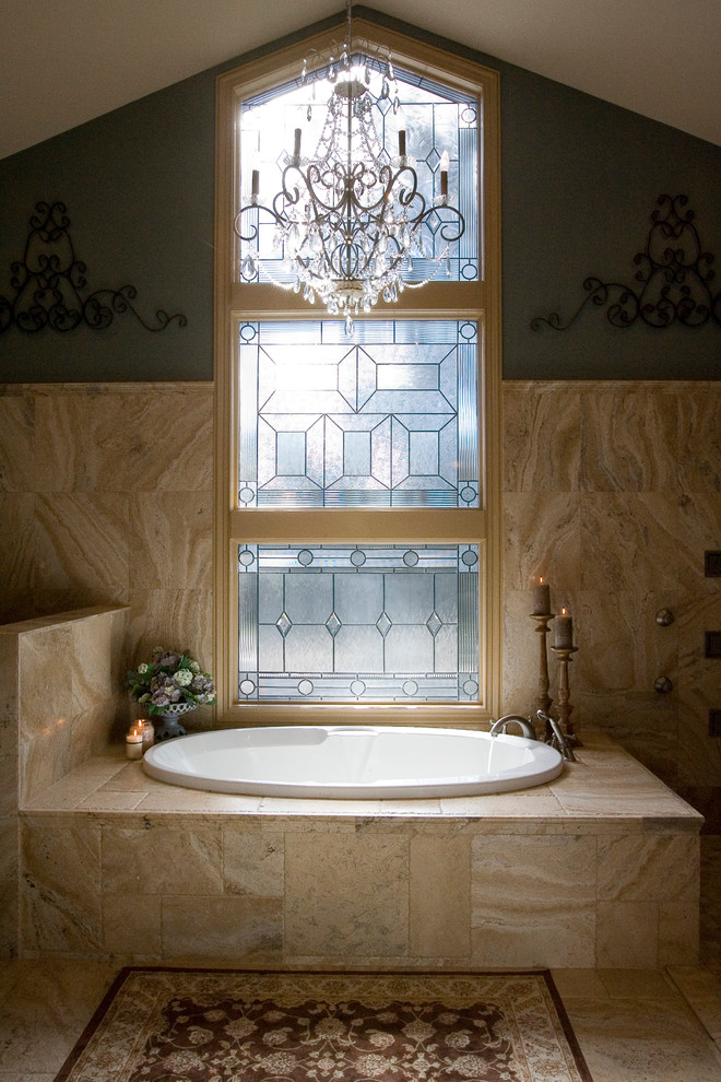 Réalisation d'une salle de bain tradition avec une baignoire posée et un carrelage beige.