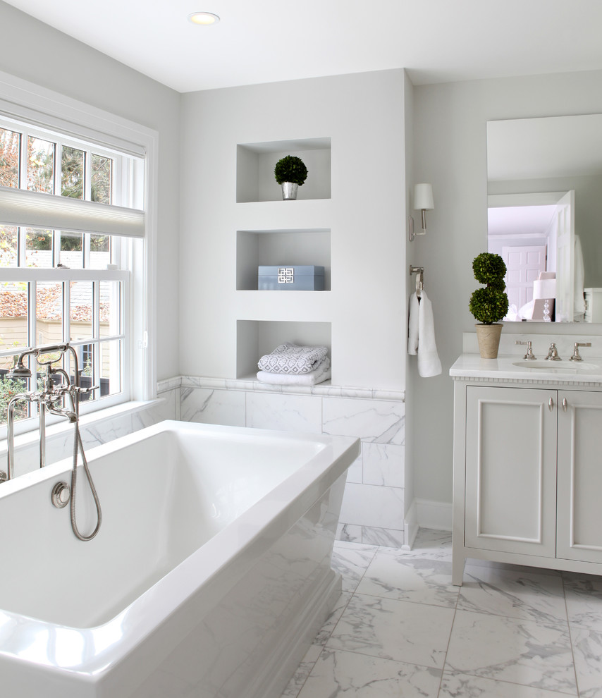 Inspiration for a large traditional ensuite bathroom in Other with recessed-panel cabinets, grey cabinets, a freestanding bath, a shower/bath combination, a one-piece toilet, grey tiles, stone tiles, white walls, marble flooring, a submerged sink and granite worktops.