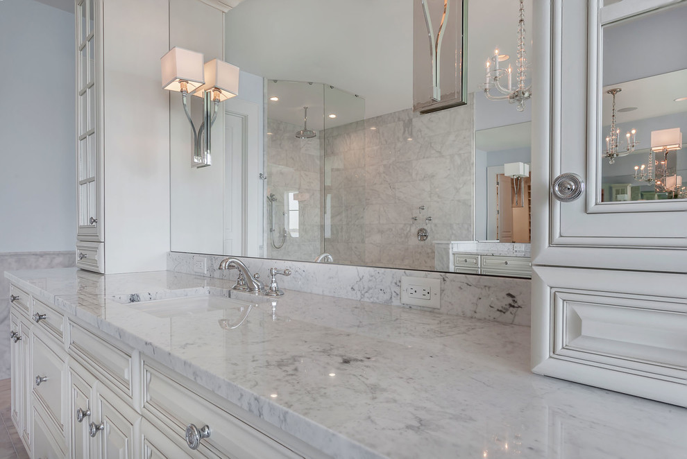 Large elegant master gray tile, white tile and marble tile marble floor and white floor freestanding bathtub photo in Tampa with raised-panel cabinets, white cabinets, blue walls, an undermount sink and quartzite countertops