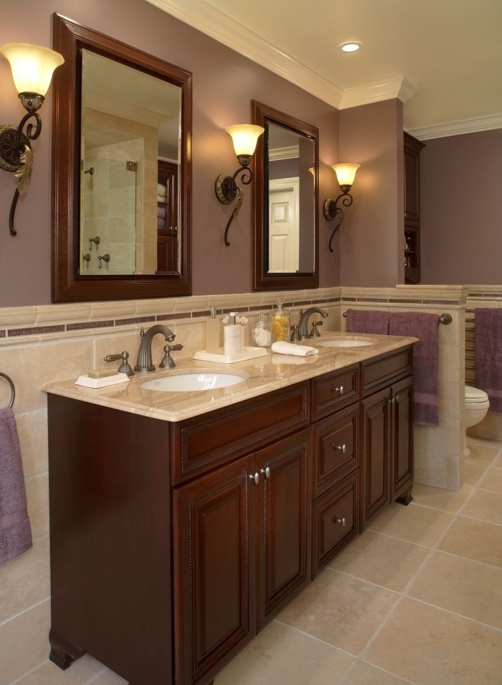 На фото: ванная комната в классическом стиле с врезной раковиной, фасадами с выступающей филенкой, темными деревянными фасадами и бежевой плиткой