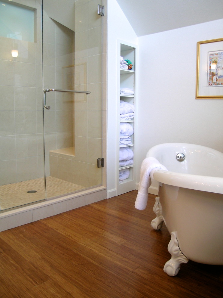 Bild på ett mellanstort vintage en-suite badrum, med marmorbänkskiva, ett badkar med tassar, en dubbeldusch, en toalettstol med hel cisternkåpa, beige kakel, stenkakel, vita väggar, bambugolv, ett undermonterad handfat, luckor med upphöjd panel, vita skåp, brunt golv och dusch med gångjärnsdörr