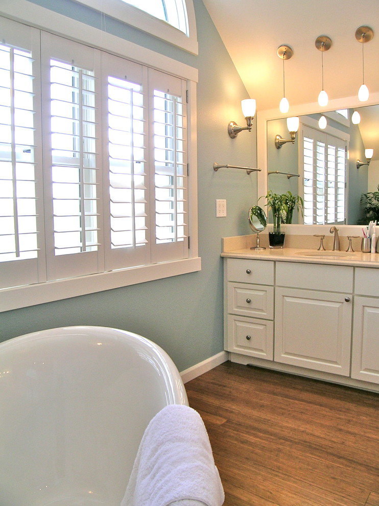 Idéer för mellanstora vintage en-suite badrum, med luckor med upphöjd panel, vita skåp, ett badkar med tassar, blå väggar, mellanmörkt trägolv, ett undermonterad handfat, granitbänkskiva och brunt golv