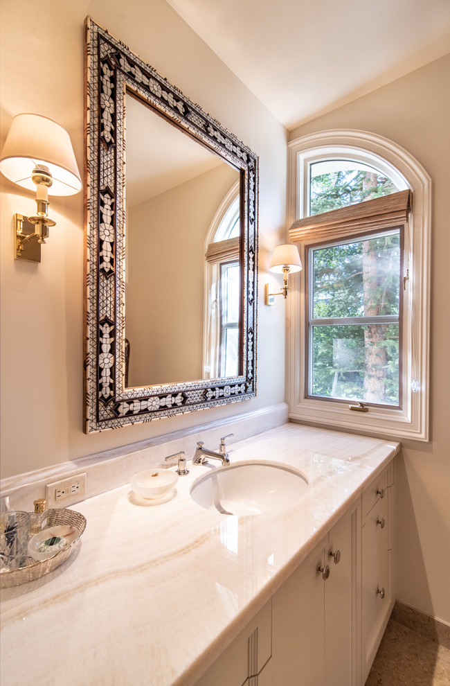 Medium sized traditional cloakroom in Denver with recessed-panel cabinets, white cabinets, beige walls, a submerged sink, granite worktops, white worktops, ceramic flooring, brown floors and a built in vanity unit.