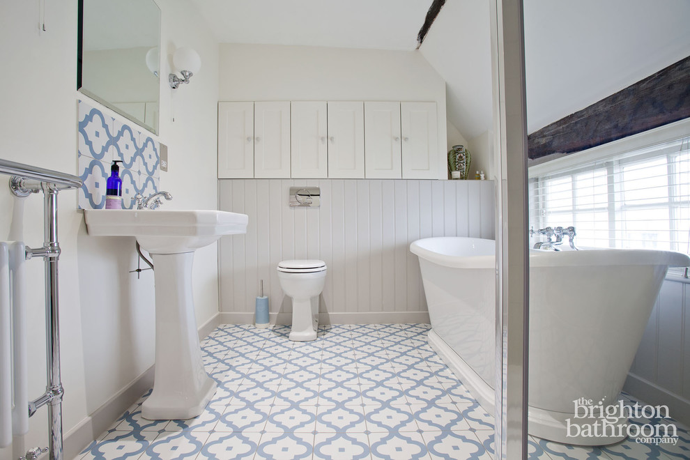 Идея дизайна: детская ванная комната среднего размера в классическом стиле с фасадами в стиле шейкер, белыми фасадами, отдельно стоящей ванной, открытым душем, унитазом-моноблоком, разноцветной плиткой, керамической плиткой, серыми стенами, полом из керамической плитки и раковиной с пьедесталом