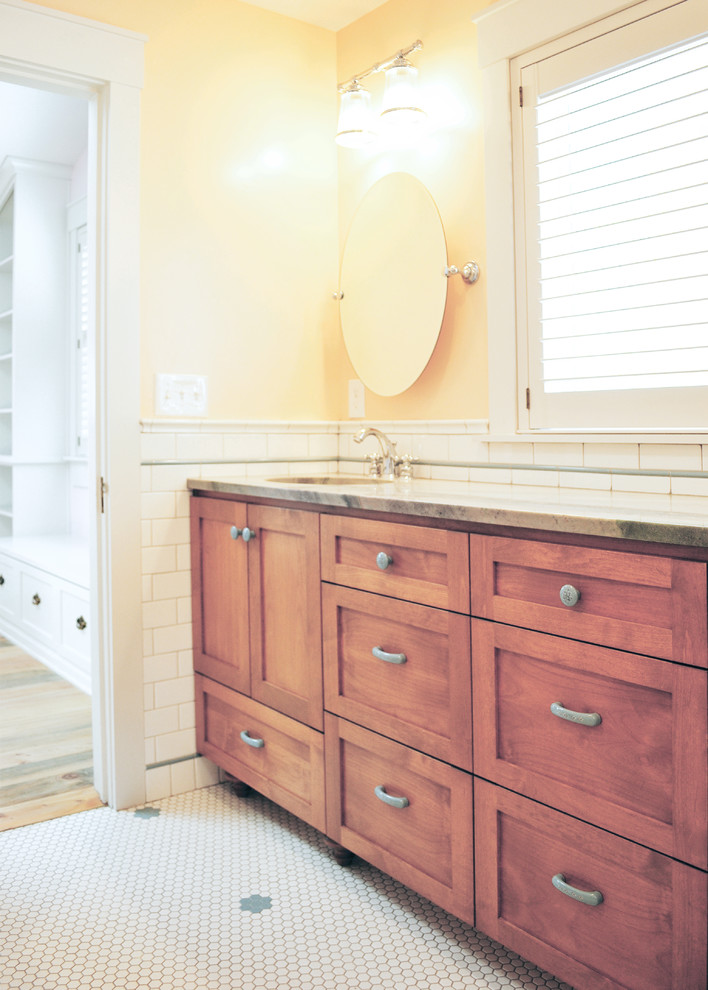 На фото: детская ванная комната среднего размера в стиле кантри с фасадами в стиле шейкер, фасадами цвета дерева среднего тона, ванной в нише, душем над ванной, раздельным унитазом, желтой плиткой, плиткой кабанчик, желтыми стенами, полом из мозаичной плитки, врезной раковиной, столешницей из кварцита, белым полом, шторкой для ванной и серой столешницей с