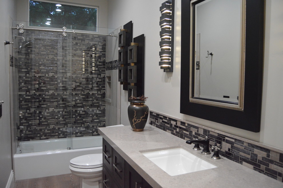 This is an example of a medium sized classic shower room bathroom in Sacramento with shaker cabinets, black cabinets, an alcove bath, a shower/bath combination, multi-coloured tiles, mosaic tiles, grey walls, light hardwood flooring, a submerged sink, granite worktops, brown floors, a sliding door and grey worktops.