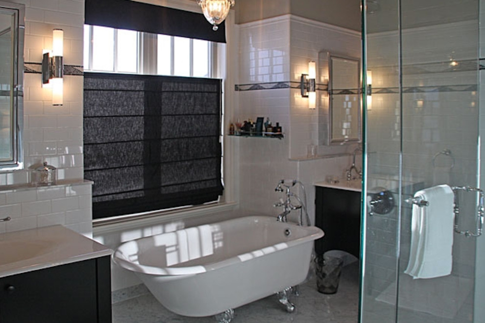 Inspiration for an expansive traditional ensuite bathroom in Calgary with an integrated sink, flat-panel cabinets, black cabinets, solid surface worktops, a claw-foot bath, a corner shower, a bidet, white tiles, metro tiles, white walls and marble flooring.