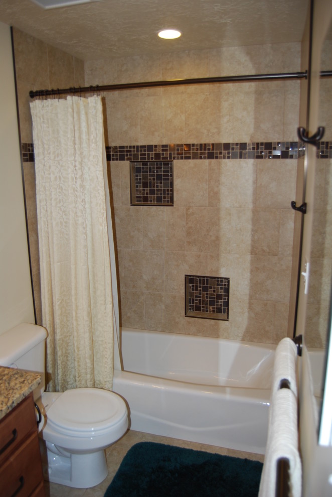 Idées déco pour une salle d'eau classique en bois brun de taille moyenne avec un combiné douche/baignoire, des carreaux de porcelaine, un placard avec porte à panneau surélevé, une baignoire en alcôve, un plan de toilette en granite, un mur beige, un lavabo encastré, un carrelage beige, une cabine de douche avec un rideau, un sol en carrelage de porcelaine et un sol beige.