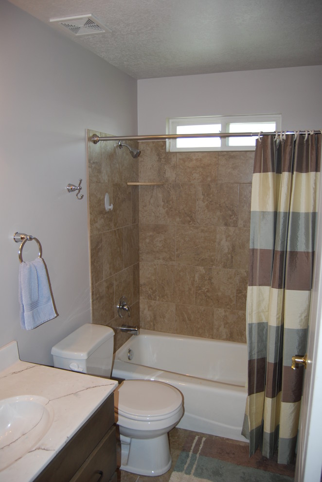 Aménagement d'une salle d'eau classique en bois brun de taille moyenne avec une baignoire en alcôve, un combiné douche/baignoire, WC séparés, un carrelage beige, des carreaux de porcelaine, un mur blanc, un lavabo intégré, un plan de toilette en surface solide, un placard avec porte à panneau encastré, un sol en carrelage de porcelaine, un sol beige et une cabine de douche avec un rideau.