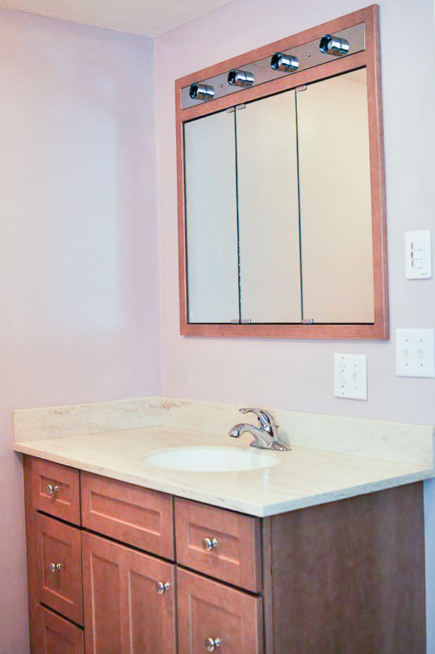 Inredning av ett klassiskt mellanstort badrum med dusch, med en dusch i en alkov, en toalettstol med separat cisternkåpa, luckor med infälld panel, bruna skåp, ett badkar i en alkov, vit kakel, rosa väggar, linoleumgolv, ett undermonterad handfat, granitbänkskiva, rosa golv och med dusch som är öppen