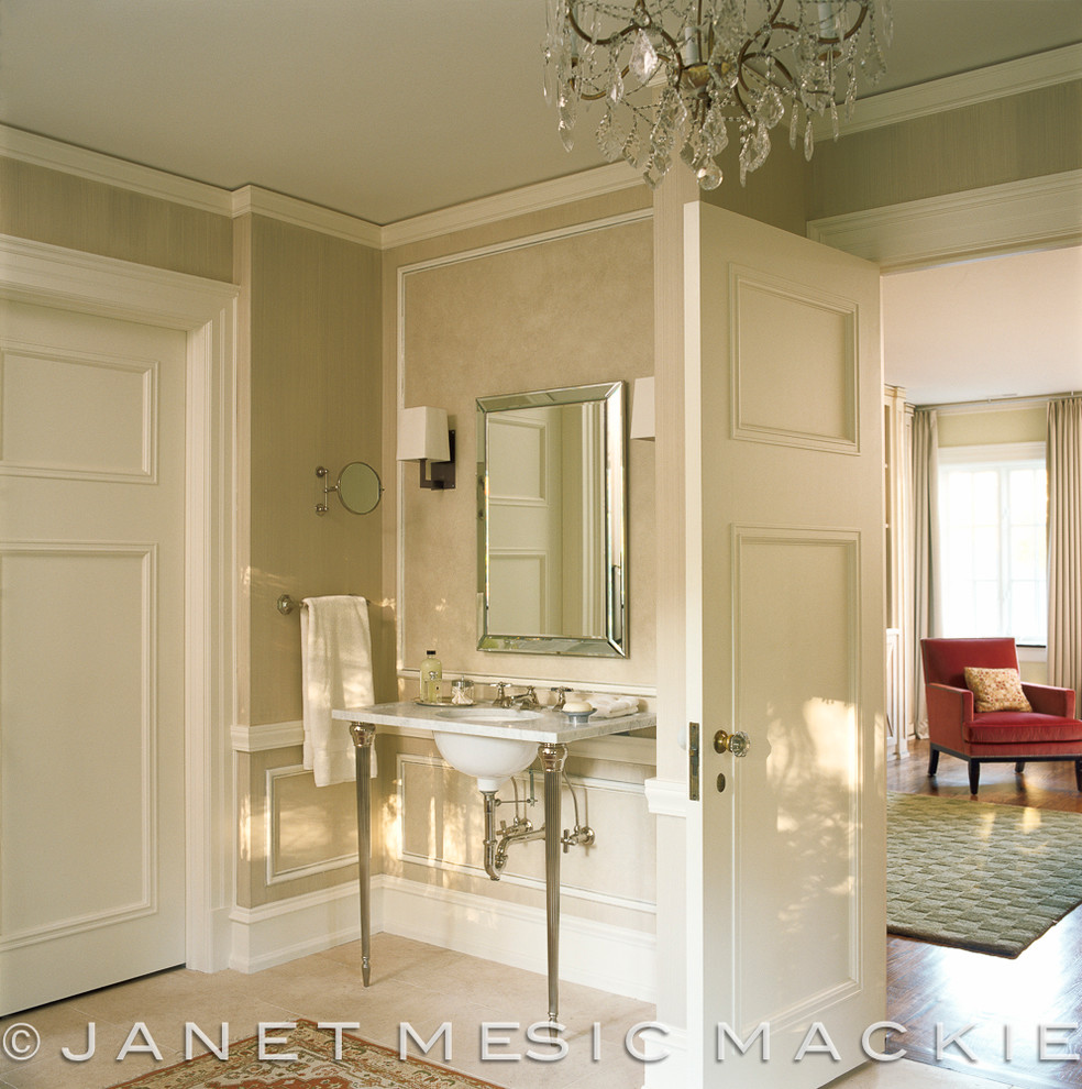 На фото: большая главная ванная комната в классическом стиле с раковиной с пьедесталом, фасадами островного типа, белыми фасадами, мраморной столешницей, бежевой плиткой, каменной плиткой, бежевыми стенами и полом из известняка с