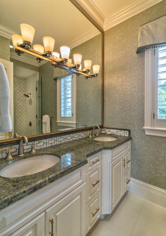 Exempel på ett stort klassiskt grön grönt badrum med dusch, med luckor med upphöjd panel, vita skåp, en dusch i en alkov, gröna väggar, klinkergolv i porslin, ett undermonterad handfat och granitbänkskiva