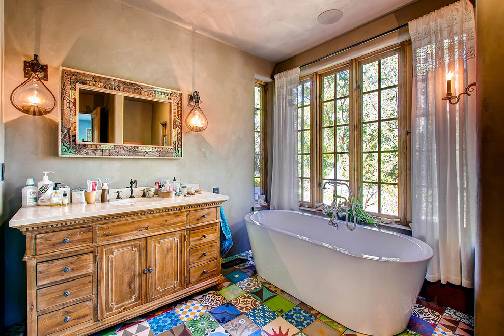 Immagine di una stanza da bagno american style con ante in legno scuro, vasca freestanding, pareti beige, lavabo sottopiano, pavimento multicolore e ante con riquadro incassato