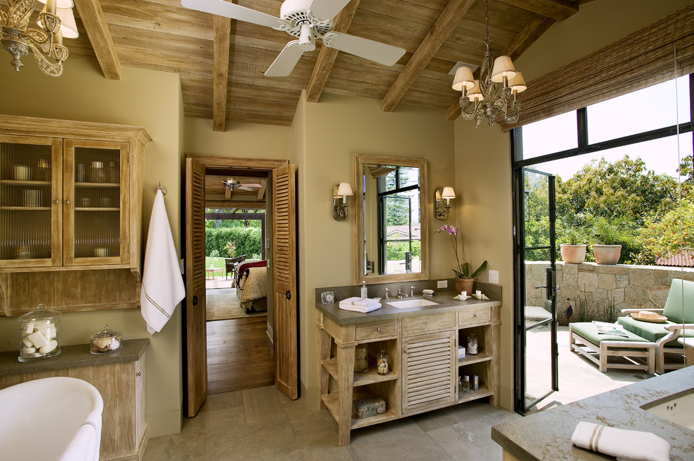 サンタバーバラにあるトラディショナルスタイルのおしゃれな浴室 (アンダーカウンター洗面器、置き型浴槽、淡色木目調キャビネット、ルーバー扉のキャビネット) の写真