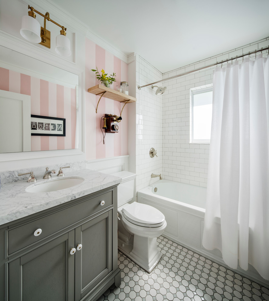 Idéer för små vintage badrum för barn, med luckor med infälld panel, grå skåp, ett badkar i en alkov, en dusch i en alkov, en toalettstol med separat cisternkåpa, vit kakel, keramikplattor, rosa väggar, klinkergolv i keramik, ett undermonterad handfat och marmorbänkskiva