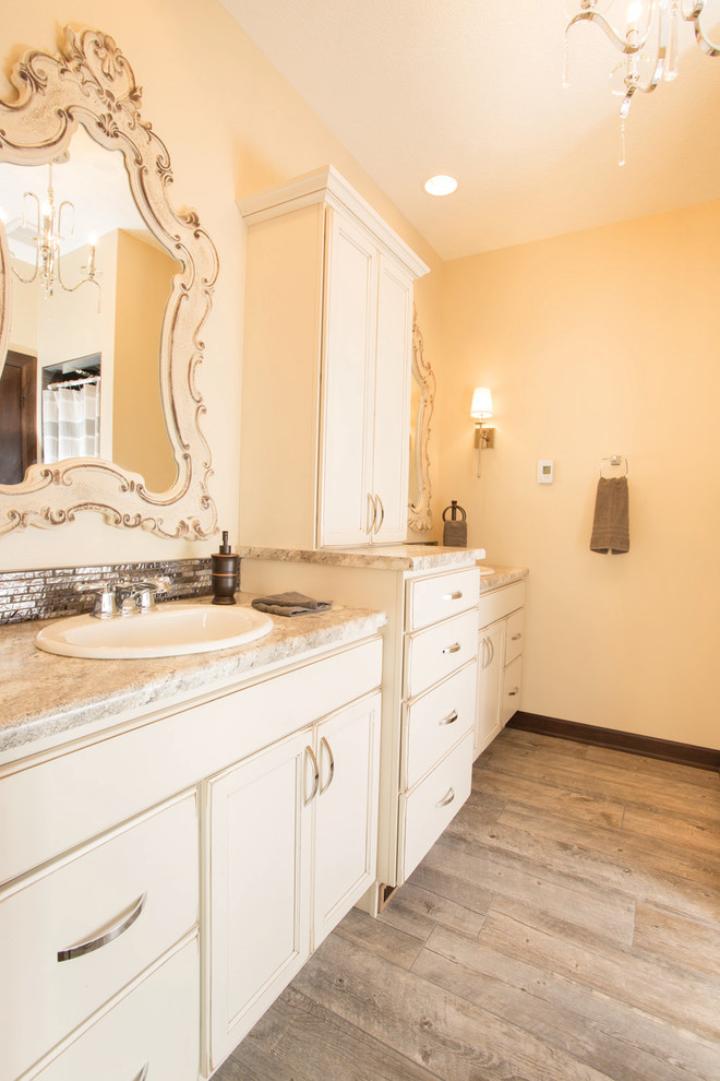 Mittelgroßes Klassisches Badezimmer En Suite mit Schrankfronten mit vertiefter Füllung, weißen Schränken, beiger Wandfarbe und hellem Holzboden in Sonstige