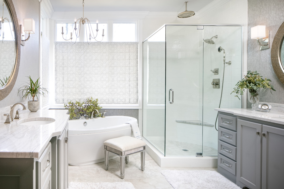 Example of a transitional master white tile white floor bathroom design in Kansas City with recessed-panel cabinets, gray cabinets, gray walls, an undermount sink and a hinged shower door