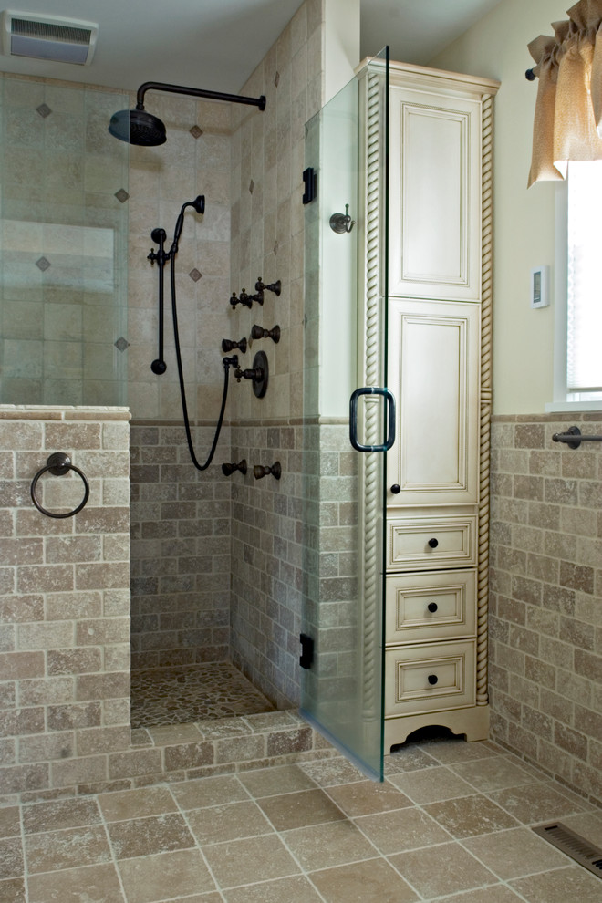Exempel på ett litet medelhavsstil en-suite badrum, med ett undermonterad handfat, vita skåp, en dusch i en alkov, beige kakel, beige väggar, travertin golv, luckor med infälld panel och travertinkakel