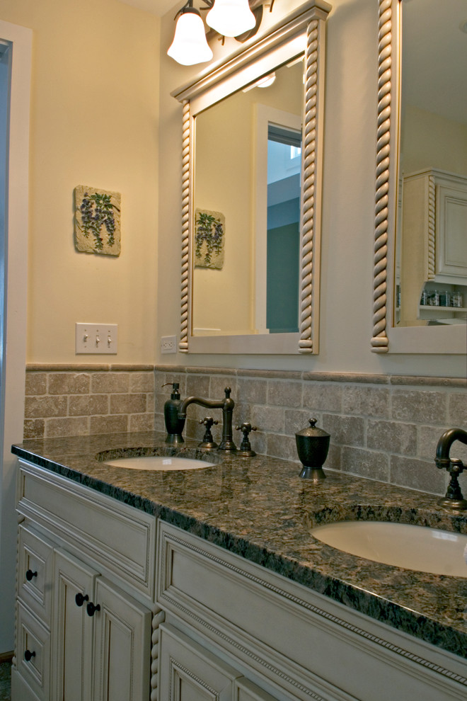 Inredning av ett medelhavsstil litet en-suite badrum, med ett undermonterad handfat, möbel-liknande, vita skåp, granitbänkskiva, en dusch i en alkov, en toalettstol med separat cisternkåpa, beige kakel, stenkakel, beige väggar och travertin golv