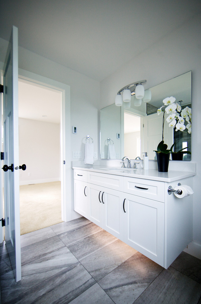 Mid-sized elegant master gray tile and ceramic tile ceramic tile doorless shower photo in Vancouver with an undermount sink, shaker cabinets, white cabinets, quartz countertops, a two-piece toilet and white walls