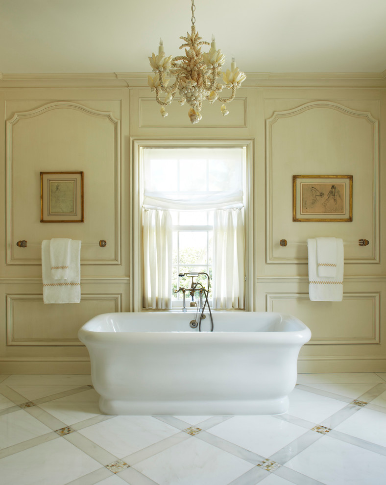 Cette image montre une très grande salle de bain principale traditionnelle avec une baignoire indépendante et un mur beige.