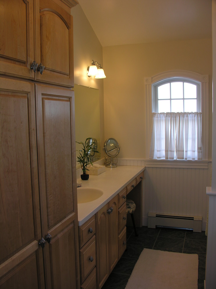 Идея дизайна: ванная комната среднего размера в классическом стиле с фасадами с выступающей филенкой, светлыми деревянными фасадами, желтыми стенами, полом из керамогранита, душевой кабиной, монолитной раковиной и столешницей из искусственного камня