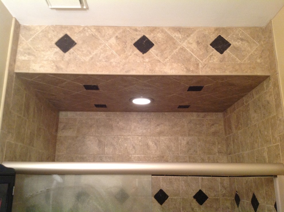 Photo of a medium sized classic shower room bathroom in Miami with raised-panel cabinets, black cabinets, a walk-in shower, a one-piece toilet, brown tiles, porcelain tiles, beige walls, porcelain flooring, a built-in sink, tiled worktops, beige floors and a sliding door.