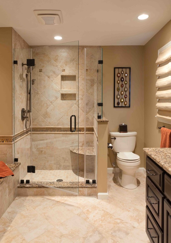 Medium sized traditional ensuite bathroom in Other with raised-panel cabinets, dark wood cabinets, a corner shower, a two-piece toilet, ceramic tiles, beige walls, travertine flooring, a submerged sink and granite worktops.