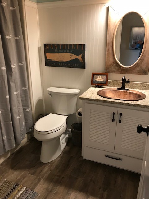 Inspiration för ett mellanstort maritimt beige beige badrum med dusch, med luckor med lamellpanel, vita skåp, ett badkar i en alkov, en dusch/badkar-kombination, vita väggar, ett nedsänkt handfat, granitbänkskiva, brunt golv, dusch med duschdraperi, en toalettstol med separat cisternkåpa och laminatgolv