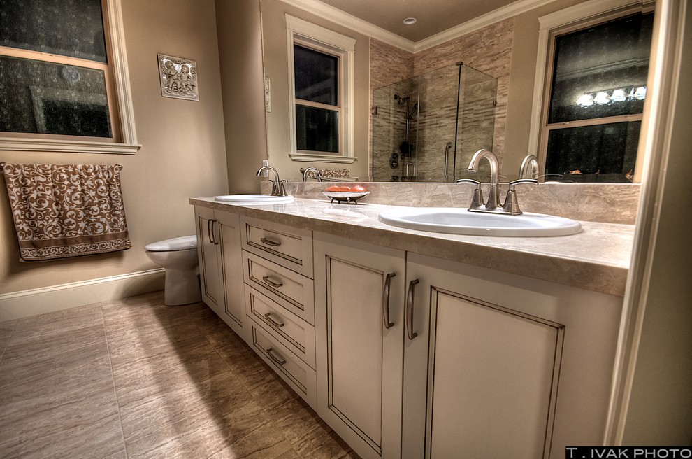 Photo of a large traditional ensuite bathroom in Vancouver with raised-panel cabinets, medium wood cabinets and granite worktops.
