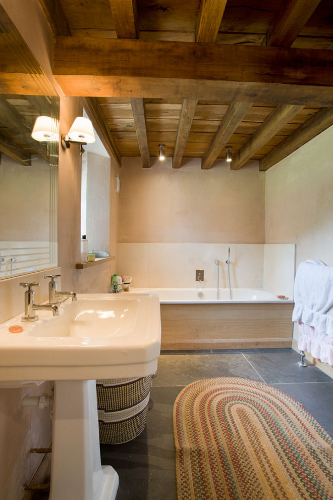 Foto de cuarto de baño de tamaño medio con bañera encastrada, suelo de pizarra y lavabo con pedestal