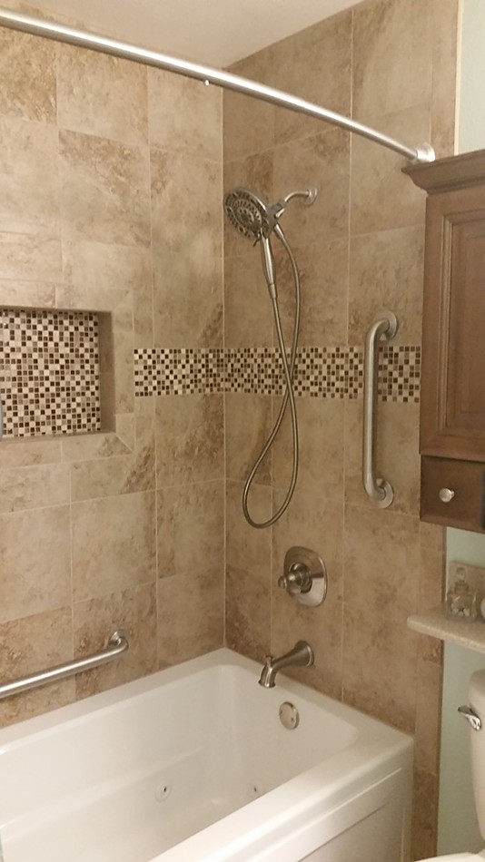 Small elegant master beige tile and ceramic tile tub/shower combo photo in Other with medium tone wood cabinets, a hot tub, a two-piece toilet, solid surface countertops, raised-panel cabinets and beige countertops