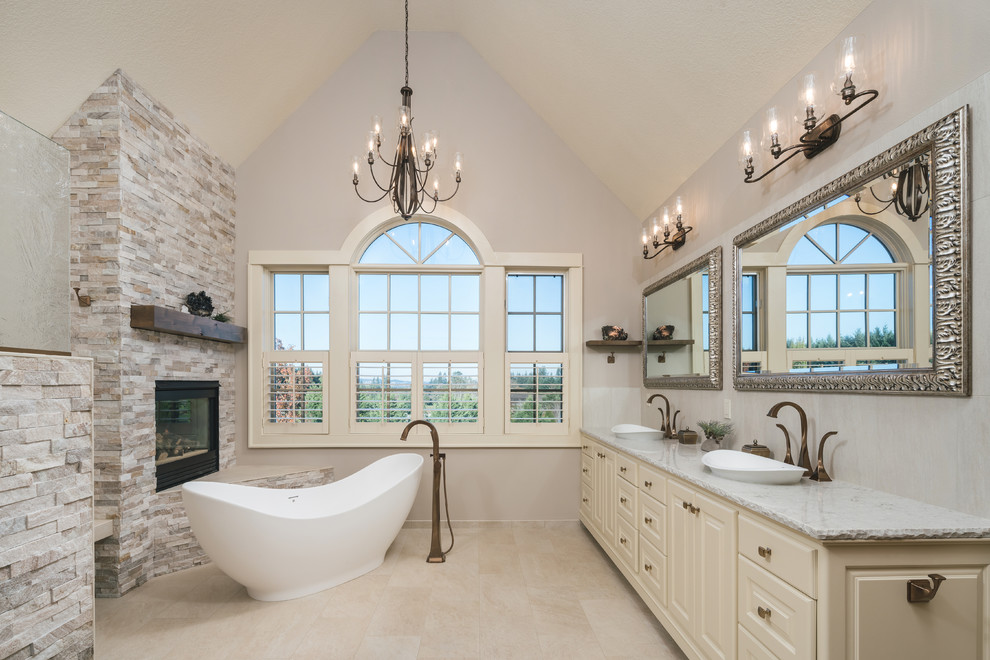 Esempio di una stanza da bagno padronale classica con ante con bugna sagomata, ante beige, vasca freestanding, pareti grigie, lavabo a bacinella, pavimento beige e top grigio