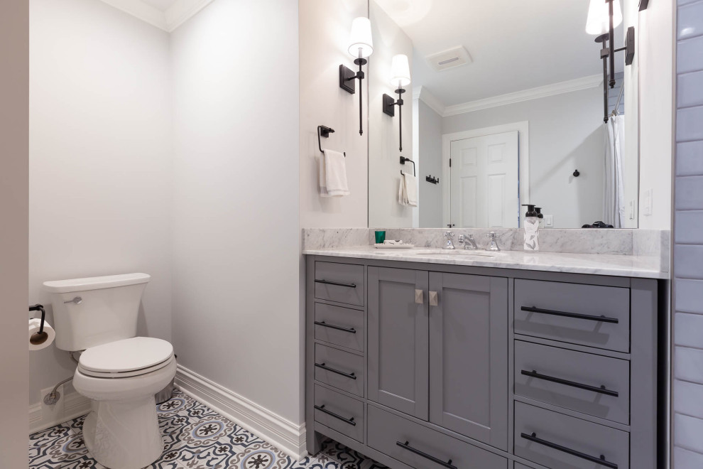 Inredning av ett klassiskt mellanstort grå grått badrum för barn, med släta luckor, grå skåp, en dusch/badkar-kombination, grå väggar, betonggolv, ett undermonterad handfat, marmorbänkskiva, grått golv och dusch med duschdraperi