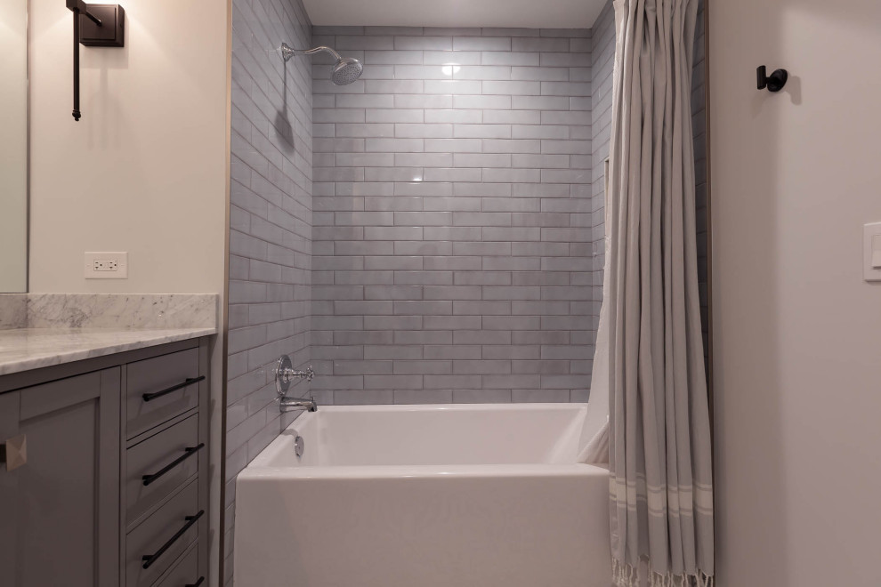 Klassisk inredning av ett mellanstort grå grått badrum för barn, med släta luckor, grå skåp, en dusch/badkar-kombination, grå väggar, betonggolv, ett undermonterad handfat, marmorbänkskiva, grått golv och dusch med duschdraperi