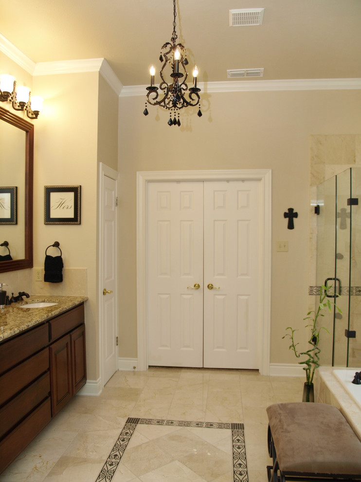 Bild på ett stort vintage en-suite badrum, med luckor med upphöjd panel, beige kakel, beige väggar, ett undermonterad handfat, granitbänkskiva, skåp i mellenmörkt trä, ett platsbyggt badkar, en toalettstol med separat cisternkåpa, marmorkakel och marmorgolv