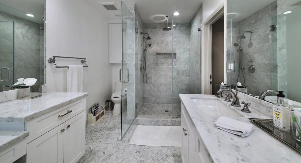 Foto på ett vintage en-suite badrum, med ett undermonterad handfat, luckor med infälld panel, vita skåp, marmorbänkskiva, vit kakel, stenkakel, marmorgolv, en hörndusch och en toalettstol med separat cisternkåpa