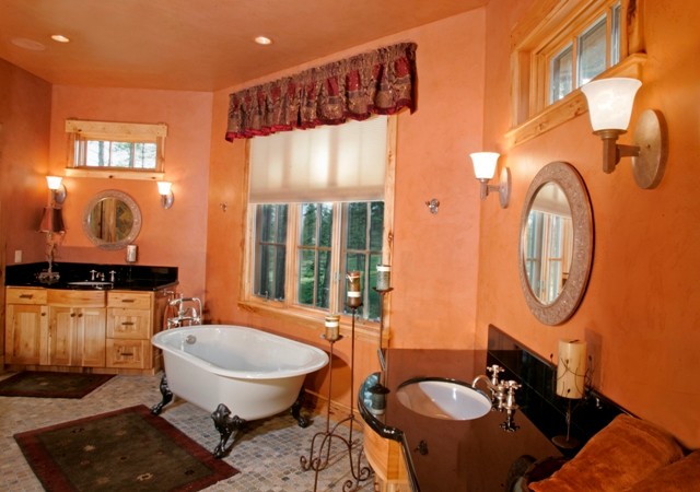Ejemplo de cuarto de baño principal rural con puertas de armario de madera clara y bañera con patas