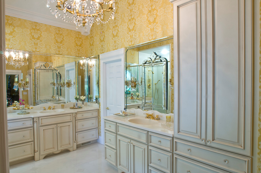 Aménagement d'une grande salle de bain principale classique avec un lavabo encastré, un placard avec porte à panneau surélevé, des portes de placard beiges, un plan de toilette en marbre, une baignoire encastrée, une douche d'angle, WC séparés, un carrelage blanc, un carrelage de pierre, un mur jaune et un sol en marbre.