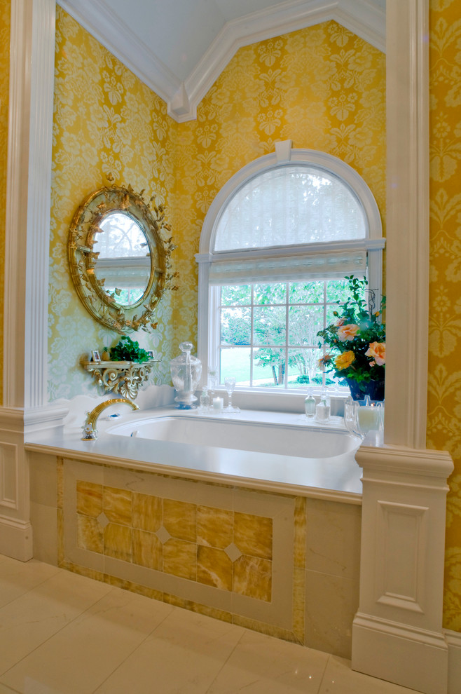 Inspiration for a large timeless master white tile and stone tile marble floor corner shower remodel in Other with an undermount sink, raised-panel cabinets, beige cabinets, marble countertops, an undermount tub, a two-piece toilet and yellow walls