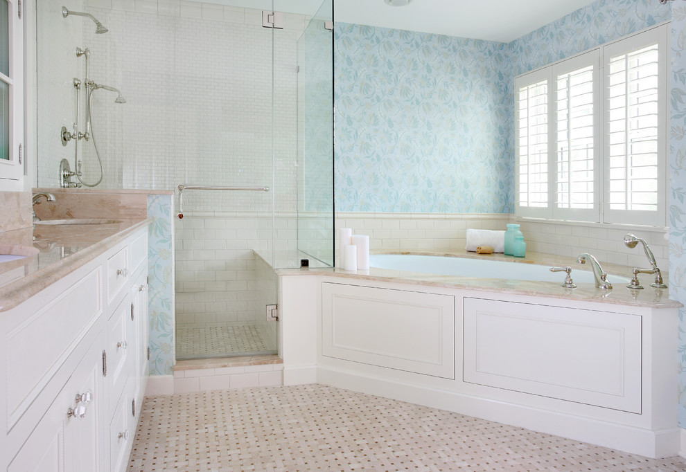 Aménagement d'une salle de bain principale classique de taille moyenne avec mosaïque, un lavabo encastré, un placard avec porte à panneau encastré, des portes de placard blanches, un plan de toilette en marbre, une douche d'angle, un mur bleu, un carrelage blanc et une baignoire encastrée.