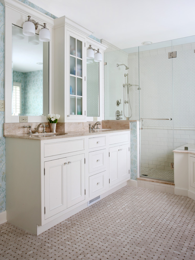 Diseño de cuarto de baño principal tradicional de tamaño medio con lavabo bajoencimera, armarios con paneles empotrados, puertas de armario blancas, encimera de mármol, ducha esquinera, baldosas y/o azulejos beige, paredes azules y suelo con mosaicos de baldosas