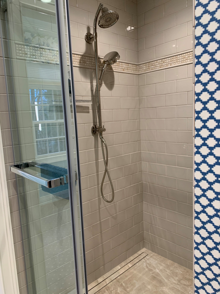 This is an example of a medium sized classic ensuite bathroom in Chicago with raised-panel cabinets, white cabinets, a submerged bath, an alcove shower, beige tiles, ceramic tiles, blue walls, porcelain flooring, a submerged sink, engineered stone worktops, beige floors, a sliding door, beige worktops, double sinks, a freestanding vanity unit and wallpapered walls.