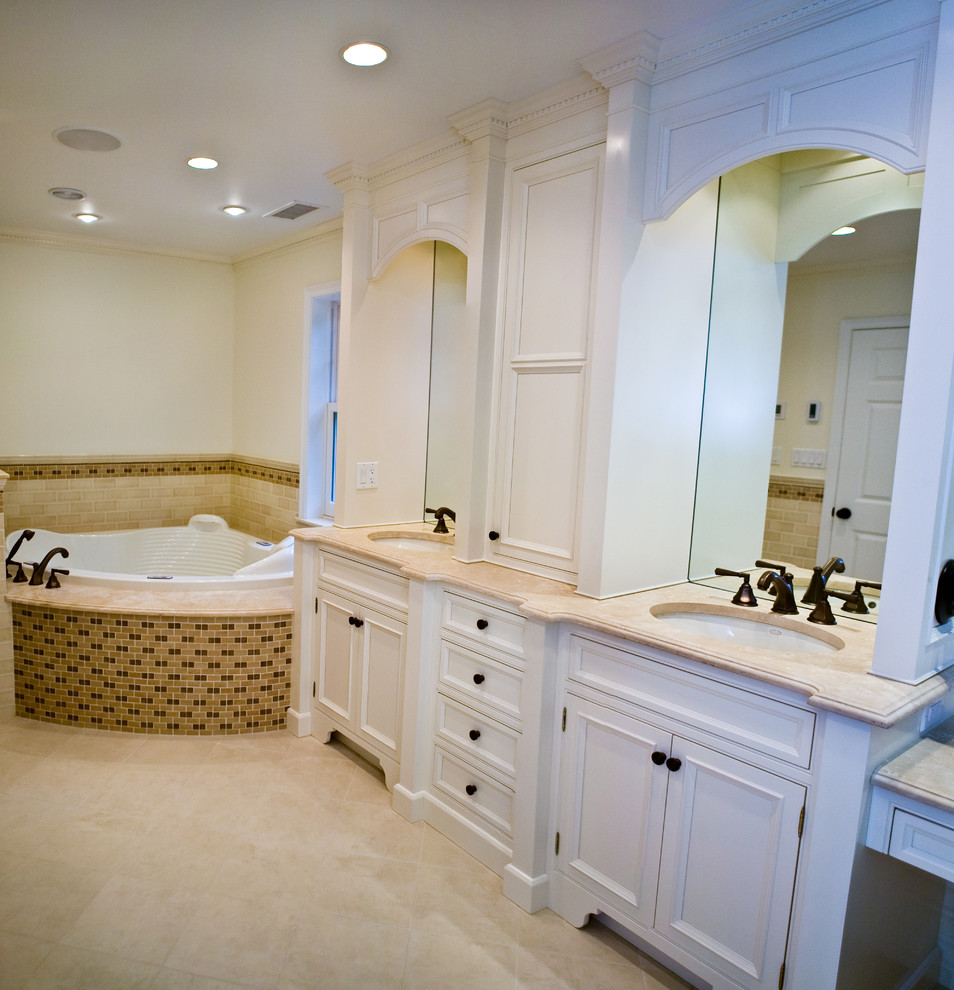 Foto på ett stort vintage en-suite badrum, med luckor med profilerade fronter, vita skåp, en jacuzzi, beige kakel, cementkakel, vita väggar, klinkergolv i keramik och ett undermonterad handfat