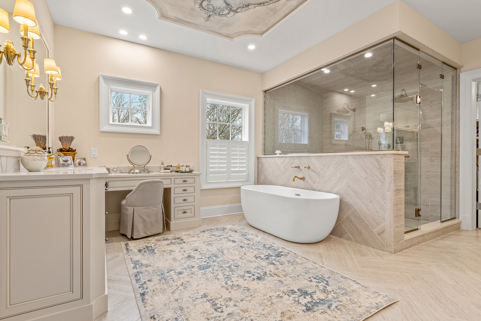 Inspiration for an expansive classic ensuite bathroom in Cleveland with recessed-panel cabinets, beige cabinets, a freestanding bath, a walk-in shower, beige walls, light hardwood flooring, a submerged sink, marble worktops, beige floors, a hinged door and beige worktops.