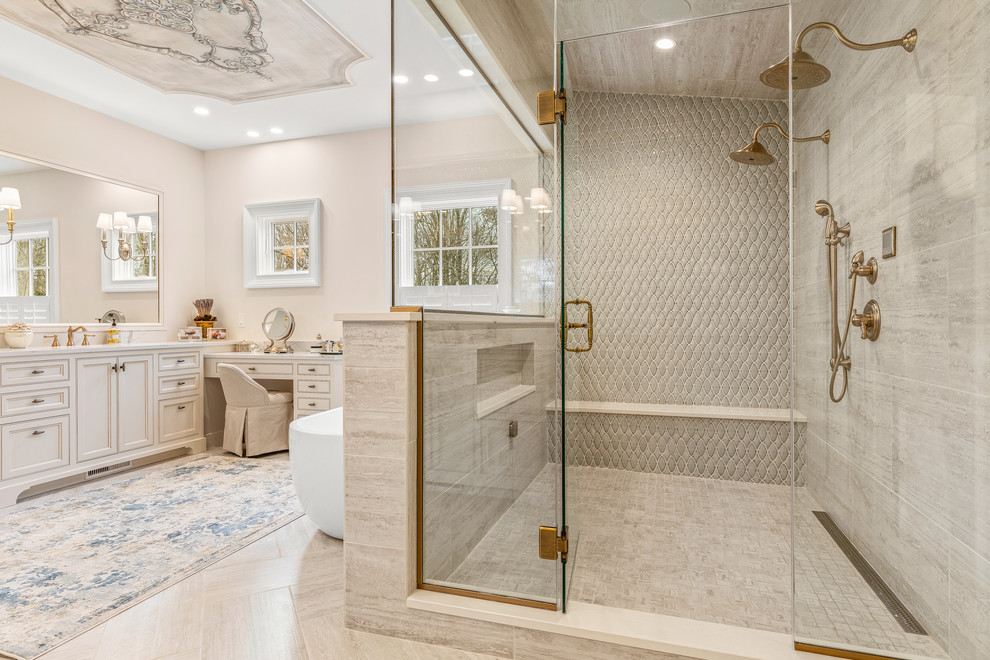 This is an example of an expansive classic ensuite bathroom in Cleveland with recessed-panel cabinets, beige cabinets, a freestanding bath, a walk-in shower, beige walls, light hardwood flooring, a submerged sink, marble worktops, beige floors, a hinged door and beige worktops.