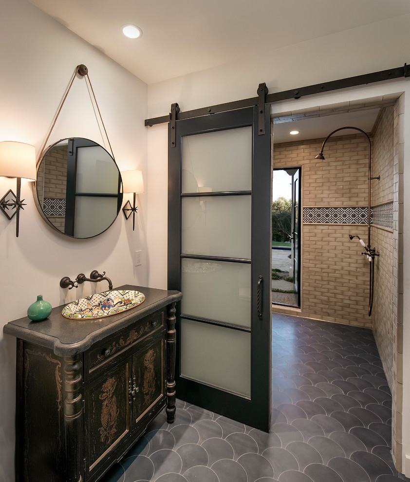 Photo of a large mediterranean bathroom in Santa Barbara with freestanding cabinets, brown cabinets, a built-in shower, beige tiles, ceramic tiles, white walls, cement flooring, a built-in sink, grey floors and a sliding door.