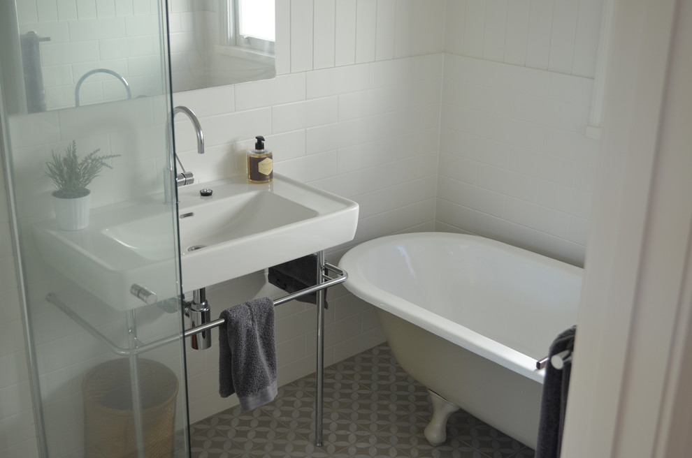 Small contemporary bathroom in Brisbane with flat-panel cabinets, medium wood cabinets, a freestanding bath, white tiles, white walls and a console sink.