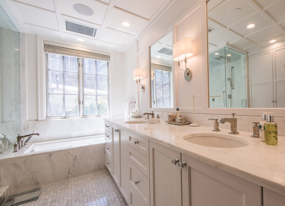 Example of a large transitional master marble tile white floor, marble floor, double-sink and coffered ceiling corner shower design in Denver with recessed-panel cabinets, gray cabinets, an undermount tub, an undermount sink, a hinged shower door, white countertops, marble countertops, white walls and a built-in vanity