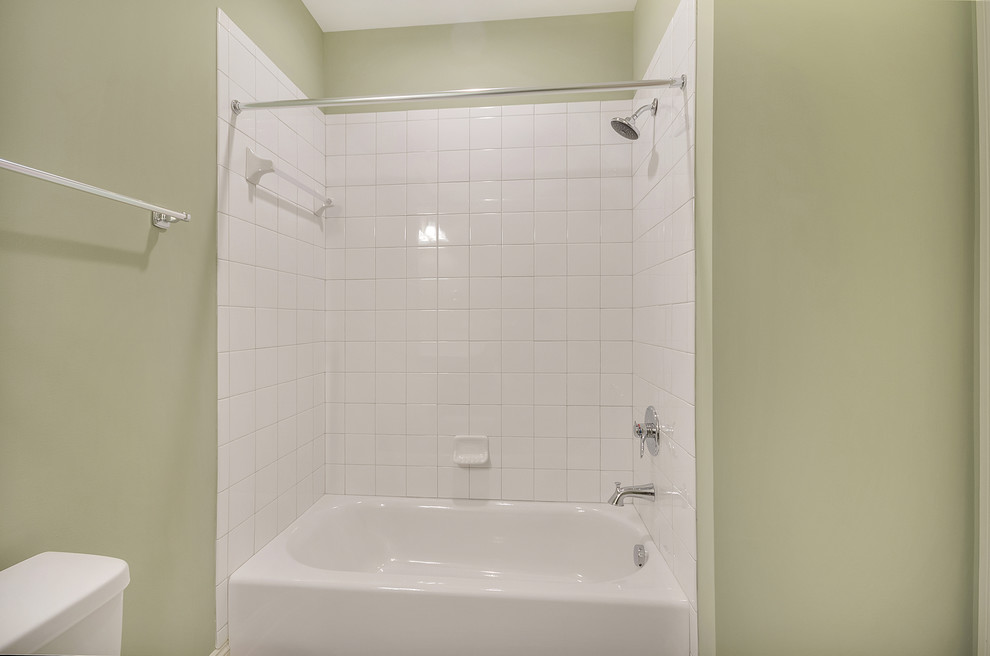 Immagine di una stanza da bagno chic con ante lisce, ante grigie, vasca da incasso, vasca/doccia, WC monopezzo, piastrelle beige, piastrelle in ceramica, lavabo da incasso, top in marmo e doccia con tenda